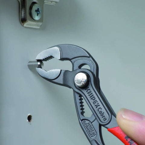 Cobra Water Pump Pliers, 5 Inch, Red, Adjustable Pliers With Self-Locking Teeth, used on a pipe for grip during installation.