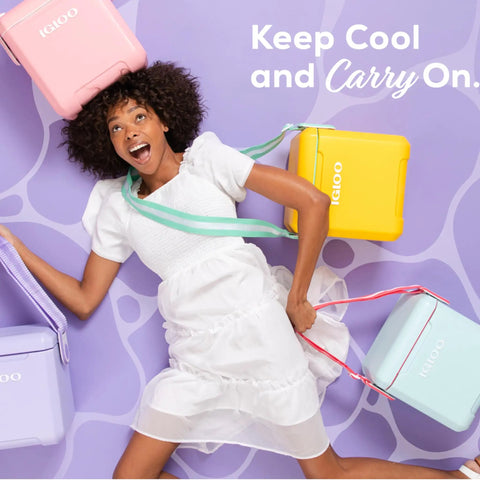 Woman lying on ground with pastel colored coolers, holding Lilac Breeze 11 Qt Tag-Along Cooler With Strapped Crossbody Carry