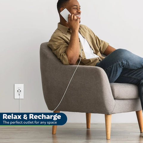 Man using phone, charging with Three Port USB Wall Outlet With Type C And Two USB A Ports, tamper resistant, in home setting.