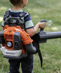 Child using 150BT Inspired Toy Bubble Leaf Blower For Kids, Realistic Air Blast With Lights, Outdoor Toddler Toys in a grassy yard