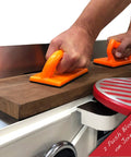 Hands using Pro Grade 4 Piece Woodworking Safety Kit with angled handle push block on a jointer, featuring bright orange grips