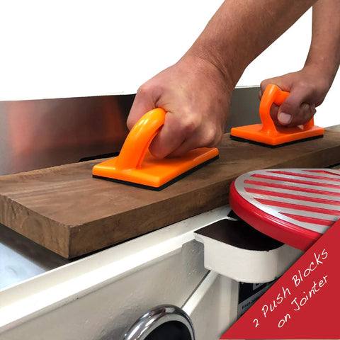 Hands using Pro Grade 4 Piece Woodworking Safety Kit with angled handle push block on a jointer, featuring bright orange grips