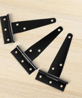 Three black 4-inch T hinges on wood, part of Six Pack 4 Inch T Hinges For Cabinets And Barn Doors Iron Lightweight Shed Hinges.