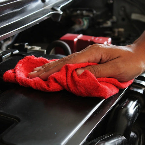 Hand using red Beefy 50 Pack Shop Towels 14x12 for automotive cleaning, showing 100% cotton towel on car engine