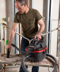 Person using 4-Gallon Portable Wet And Dry Vacuum Cleaner With A 5.0 Peak HP Motor on a jobsite, featuring grab-and-go lightweight design.