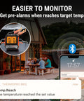 Bluetooth Meat Thermometer with 450 ft range and 2 probes displaying temperature alert on phone app at outdoor BBQ.