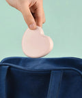 Hand holding a pink heart-shaped case for the Compact Travel Sewing Kit Two Pack Featuring Adorable Heart Shaped Cases Pink And Blue.
