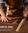 Solid Wooden Scratching Awl For Leatherwork And Bookbinding With Comfort Grip Hella Durable Total Game Changer For Precision Marking Fast Stitch Removal And Everyday Embroidery Projects Built Tough To Last, held by craftsman on brown fabric.