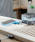 Foam Back Contouring Abrasive Discs with Hook and Loop Mount next to box, on a detailed wood surface in workshop.