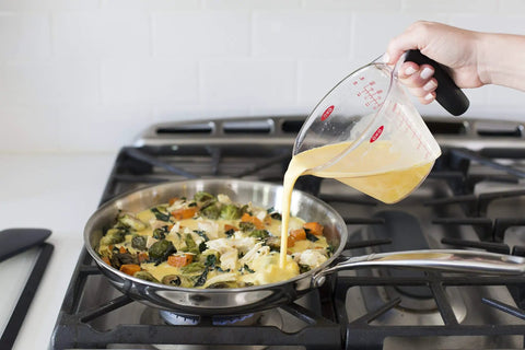 Angled 2 Cup Measuring Cup With Easy Read From Above Measurements pouring mixture into skillet on stove