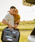 Man carrying Dual Fuel Portable Generator With 4000W Peak And 3200 Running On Gas Or 3600 Peak And 2800 Running On Propane, with child