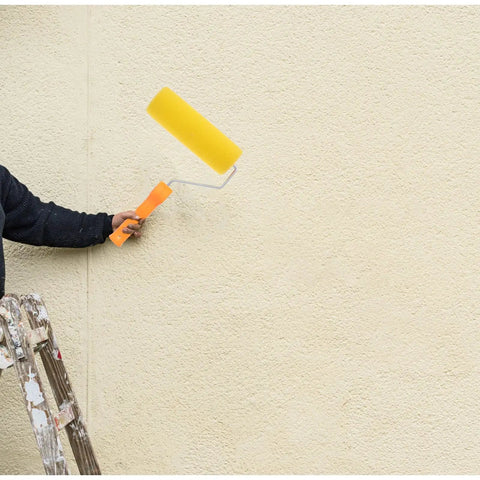 Textured Sponge Paint Roller For Wall Painting With Ergonomic Handle held by a person on a ladder against a light wall.