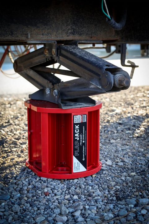 Magnetic RV Jack Stabilizer Blocks Four Pack positioned under RV jack on gravel surface for leveling trailers.