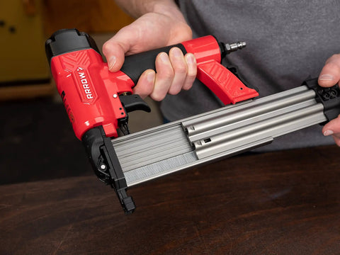 Person holding Oil Free 18 Gauge Pneumatic Brad Nailer for Small Trim and Interior Molding Fires Up to 100 PSI Handles 5/8 to 2 Inch