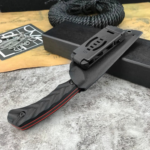 Fixed Blade Knife With D2 Steel Blade, Textured G10 Handle, And Kydex Sheath For Safe Carry shown in sheath on grey background.