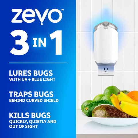 Plug In Flying Insect Trap For Fruit Flies And Gnats Using Blue And Uv Light With Zero Mess Adhesive Cartridge To Keep Your Spot Bug Free Includes Two Base Units And Two Sweet Refills That Chase Pests Night And Day For Low Key Indoor Fly Elimination mounted on wall with fruit bowl nearby.
