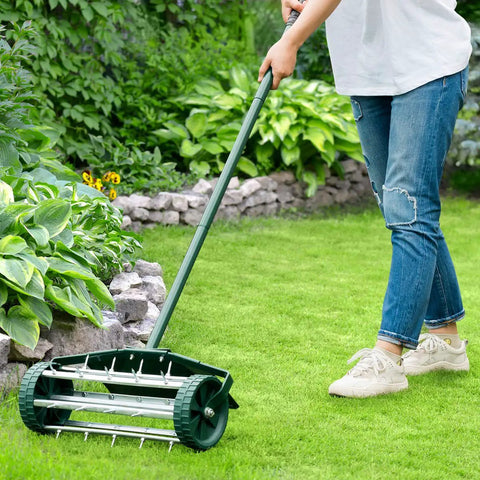 Woman using Rolling Lawn Aerator 18 Inch Garden Yard Rotary Push Tine Heavy Duty Spike Soil Aeration Tool with 41 Inch Handle