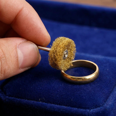 Close-up of 1 Inch Mini Polishing Wheels Set 100 Pcs Abrasive Buffing Wheels with ring and blue background, held by hand.