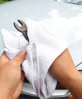 Hands using Bulk Terry Cloth Cleaning Rags 300 Pack, 14x17 Inch 100% Cotton Towels for Kitchen, Auto Shop, and Bar Use on a wrench
