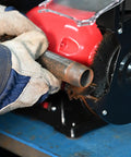 User operating a Six Inch Wide Face Bench Grinder Wire Wheel on a rusty metal pipe in a workshop.