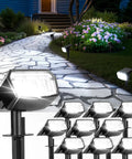 Ten Pack Solar Spot Lights Outdoor IP67 Waterproof With 63 LED Ultra Bright Landscape Spotlights illuminating a garden pathway