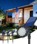 Multicolor Solar Lights Outdoor Pack Of 4 With 18 LEDs Waterproof Landscape Spotlights in front of a lit house