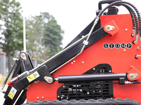 Side view of Stomp Mini Skid Steer Loader with 1800 lb capacity and lawn scarifier attachment for small jobs and landscaping.