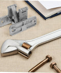 Close-up of concealed heavy-duty door hinge kit with mounting plates, bolts, and wrench