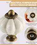 Antique White Pumpkin Ceramic Cabinet Knobs 2 Pack With Screws For Vintage Drawer Pulls with bronze accents close-up view
