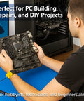 Side view of person wearing a yellow anti-static wrist strap connected to grounding plug, holding a motherboard over a blue work surface.