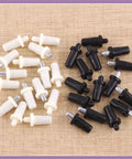 60 Piece 4 Sizes Spring Loaded Cabinet Door Repair Pins Set for shutters and doors, black and white pins on wood surface