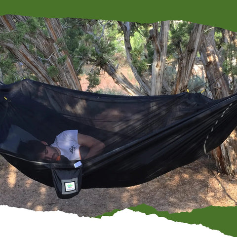Man sleeping in Bug Free Sky Bed Camping Hammock Tent With Flat Lay Sleep under trees, showcasing asymmetrical design and pad sleeve.