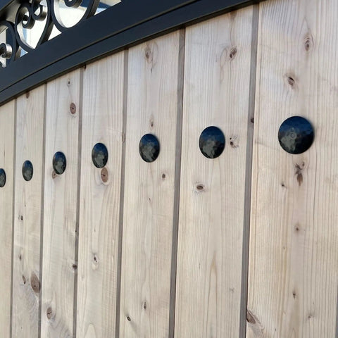 Top Shelf Matte Black Clavo Nails 50 Pack 1.5 Inch Decorative Studs on rustic wooden barn door for upholstery use.