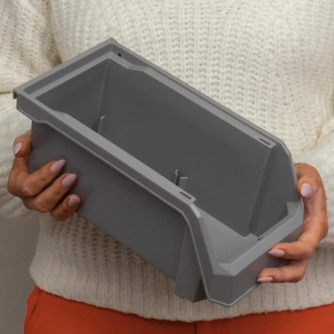 Medium Plastic Storage Bin in gray, held by person in a sweater, with open front design for easy access.