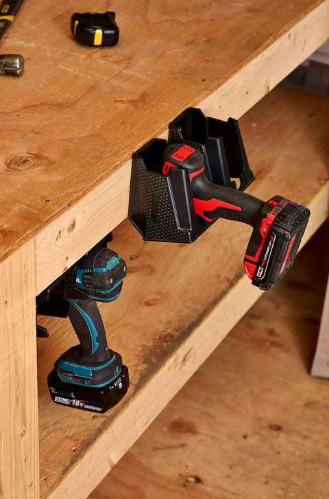 Universal Drill Holder And Power Tool Organizer Wall Mount Rack for Cordless Drills, installed under wooden bench with two drills.