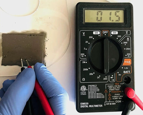Conductive Paint Pen For Quick Circuit Repairs And EMF Shielding used with multimeter showing conductivity reading, precision work.