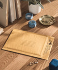 Desk with Kraft Bubble Mailers 6x9 Inches Size 0 Self Sealing Manila Mailers Pack Of 25 and stationary items.