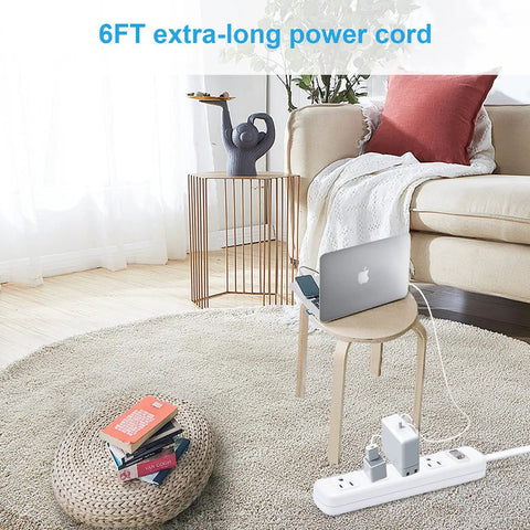 Living room with a Wall Mounted Power Strip With Four Outlets, Surge Protector, Six Foot Extension Cord beside a chair and laptop.
