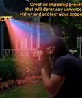 Solar Outdoor Motion Sensor Alarm Kit installed on house wall, emitting light, showing security deterrent effect, garden setting