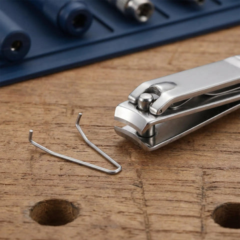 Quick Rebound Stainless Steel Torsion Springs For Nippers And Pruning Shears. Durable Pedicure Tool Replacement Hardware That Slides In Effortlessly For Smooth Clipping Action Every Time. Get Your Beauty Instruments Back To Crisp Working Condition With. stainless steel spring beside nail nipper on wood