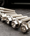 Titanium M6 Flanged Hex Bolts Set, 1.0mm Pitch, Assorted Lengths 5 To 80mm, Ti 6Al 4V Grade 5 Alloy, close-up view on ground