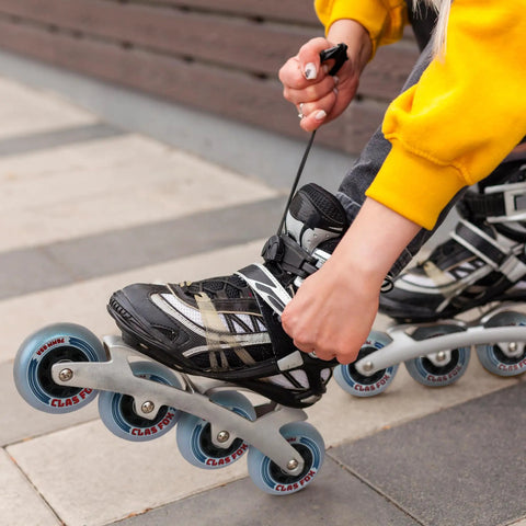 Person adjusting inline skate with Inline Skate Replacement Wheels With ABEC 9 Bearings And Floating Spacers For 72mm And 76mm Skates 85A
