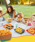 Colorful 12 Piece Chip and Dip Serving Platter Set BPA Free Plastic Snack Trays at outdoor party with sushi and chicken.