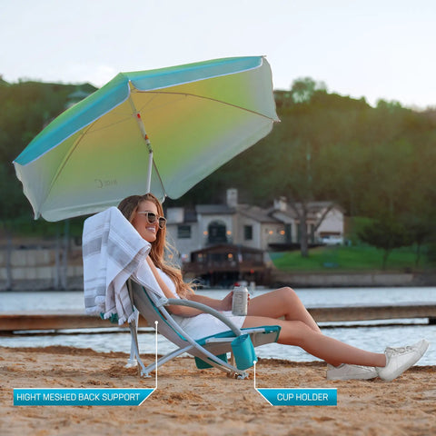 Person relaxing on High Back Beach Chair With Umbrella And Cooler Cup Holder And Carry Bag at beach, featuring a cup holder.