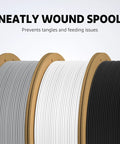 Three PLA filament spools on cardboard cores in gray, white, and black.
