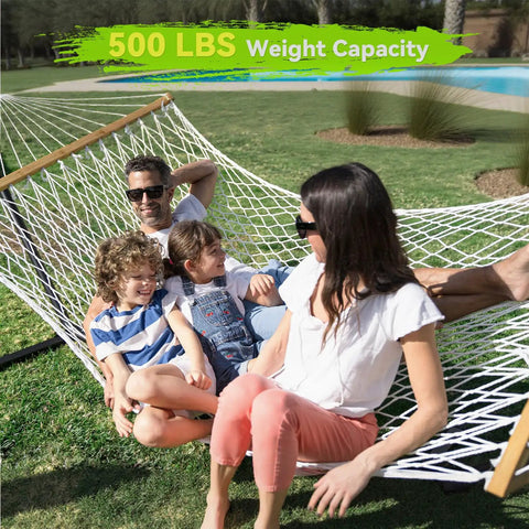 Family relaxing on double handwoven rope hammock for two with spreader bar, outdoor use, white, supports up to 450 lbs, 74.8 x 55.1 inch bed.