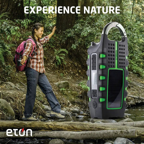 Rugged Multipowered Portable Emergency Weather Radio And Flashlight With Hand Crank Solar Power USB Smartphone Charger shown outdoors