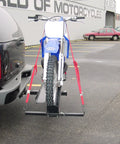 Front view of Dirt Bike Hitch Carrier With Ramp for 2 Inch Class III and IV Hitches, mounted on a vehicle, securing a blue dirt bike.
