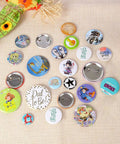 Custom DIY badges made with Dope 58mm Button Maker Kit For DIY Badges With 100 Sets And 10 Bonus Keychains on beige fabric.