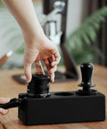 Hand using Walnut 4 In 1 Espresso Knock Box And Tamping Station With Portafilter Holder Tamper Holder And Distributor Holder For 51 To 54 Mm Espresso Gear